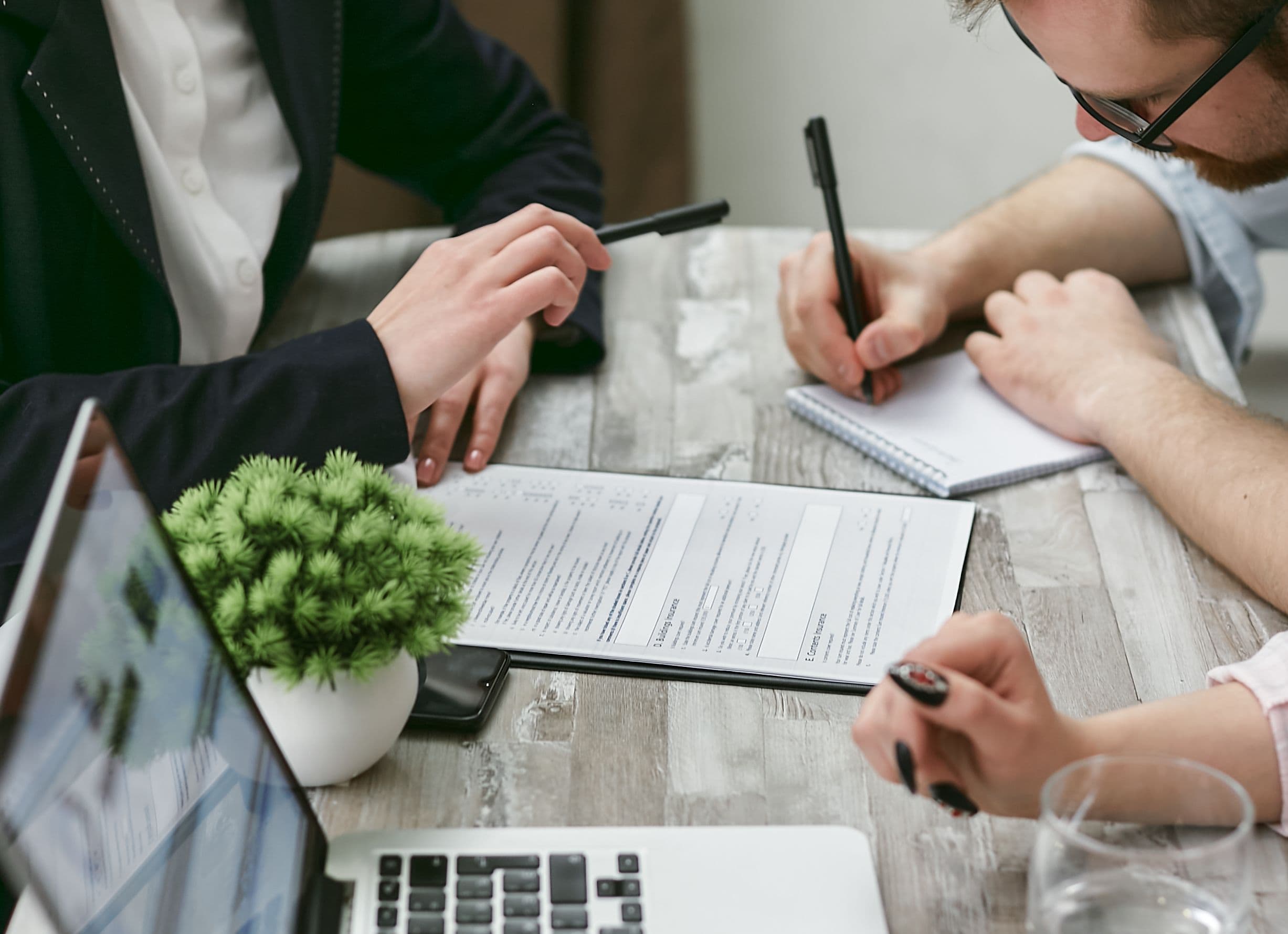 Advisor reviewing paperwork and notes with a client at a table