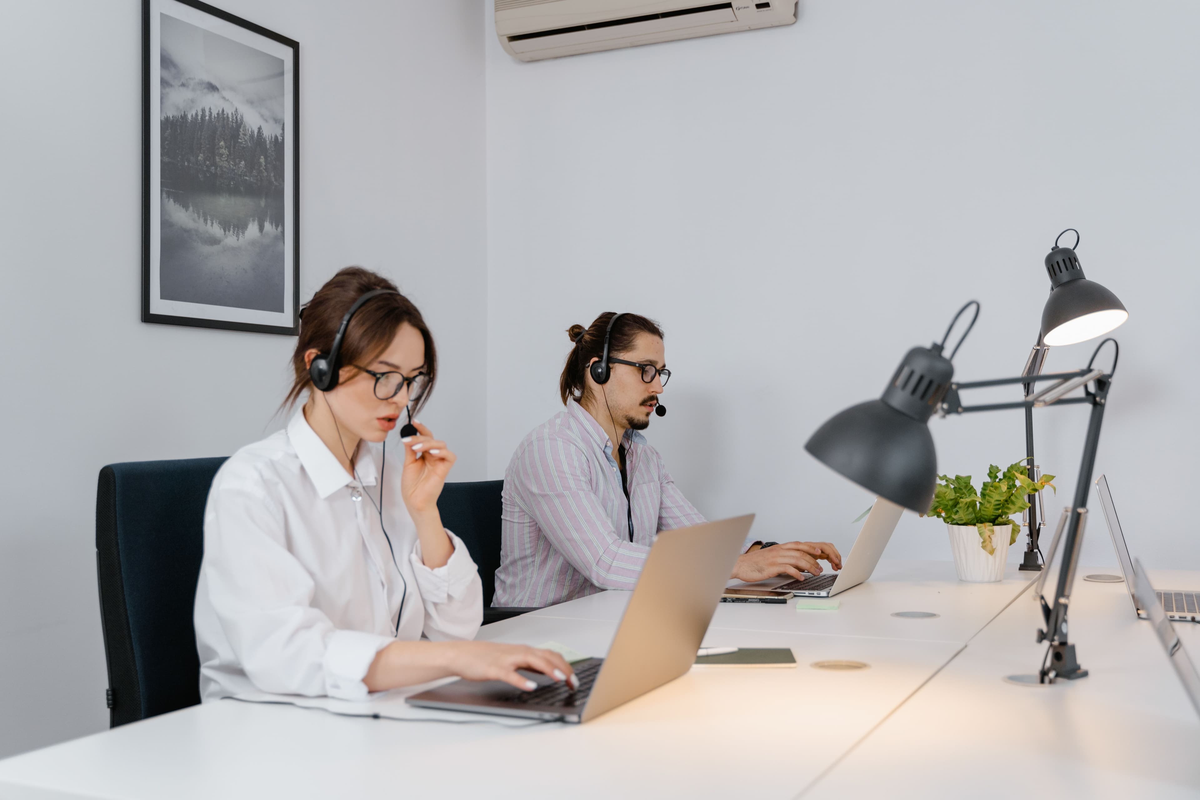 Support advisors wearing headsets and helping customers from a shared office
