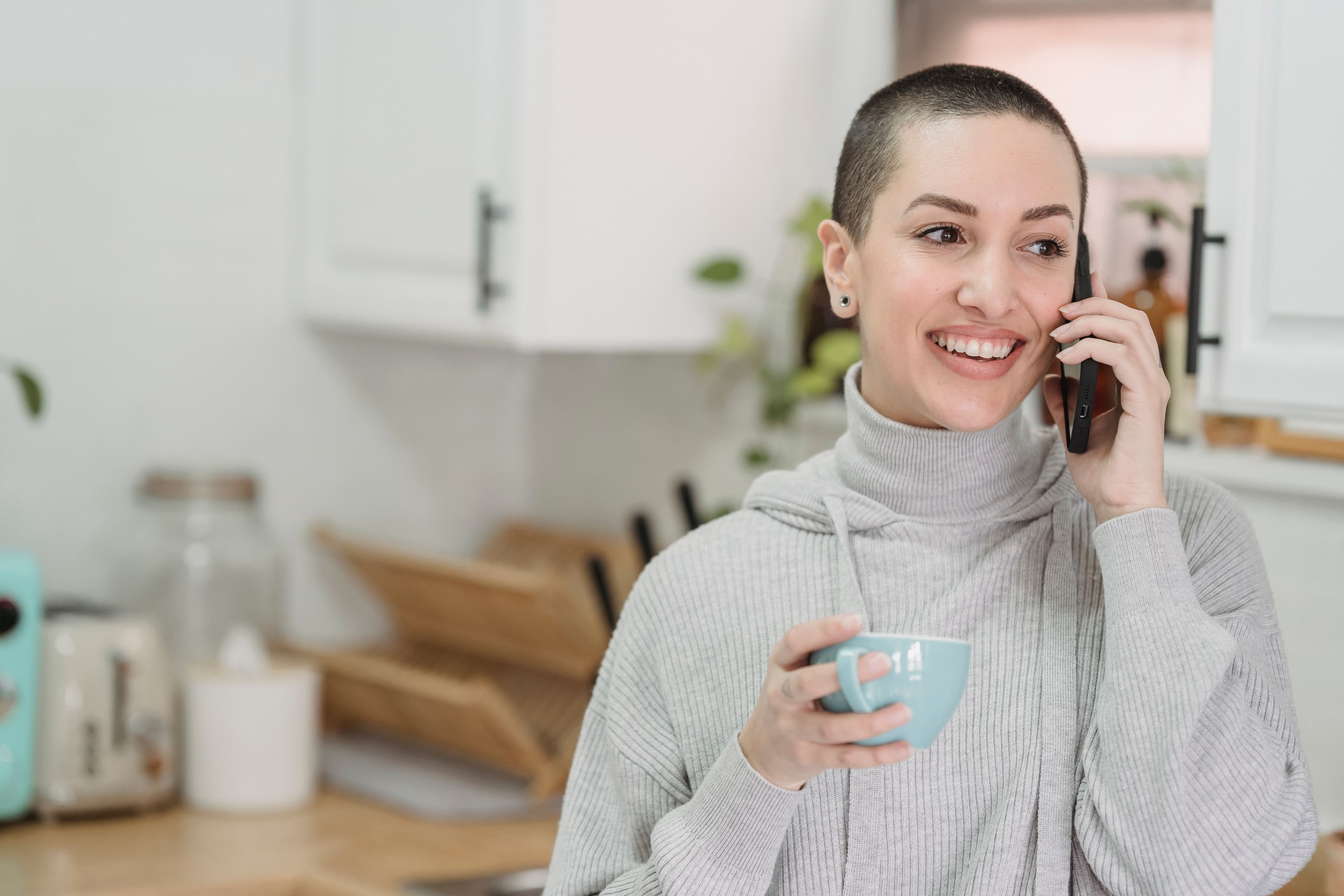 Protecta advisor speaking on the phone while holding a cup in a bright kitchen